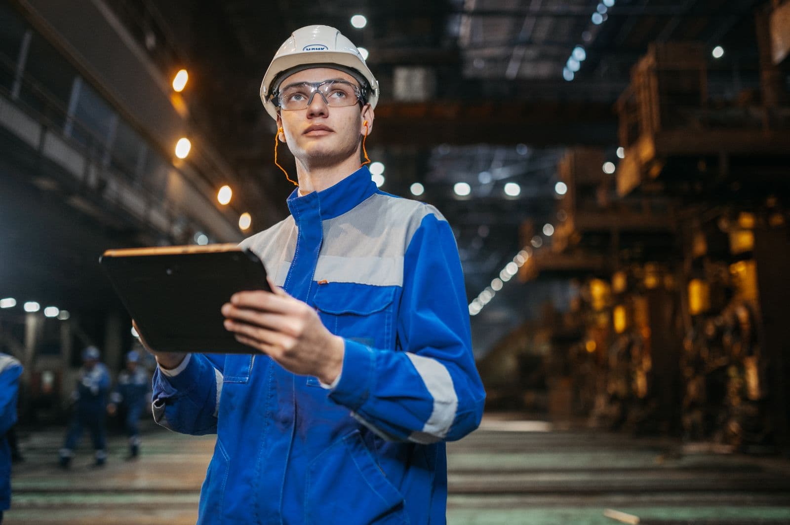 Engineer holding a tablet on an industrial production floor